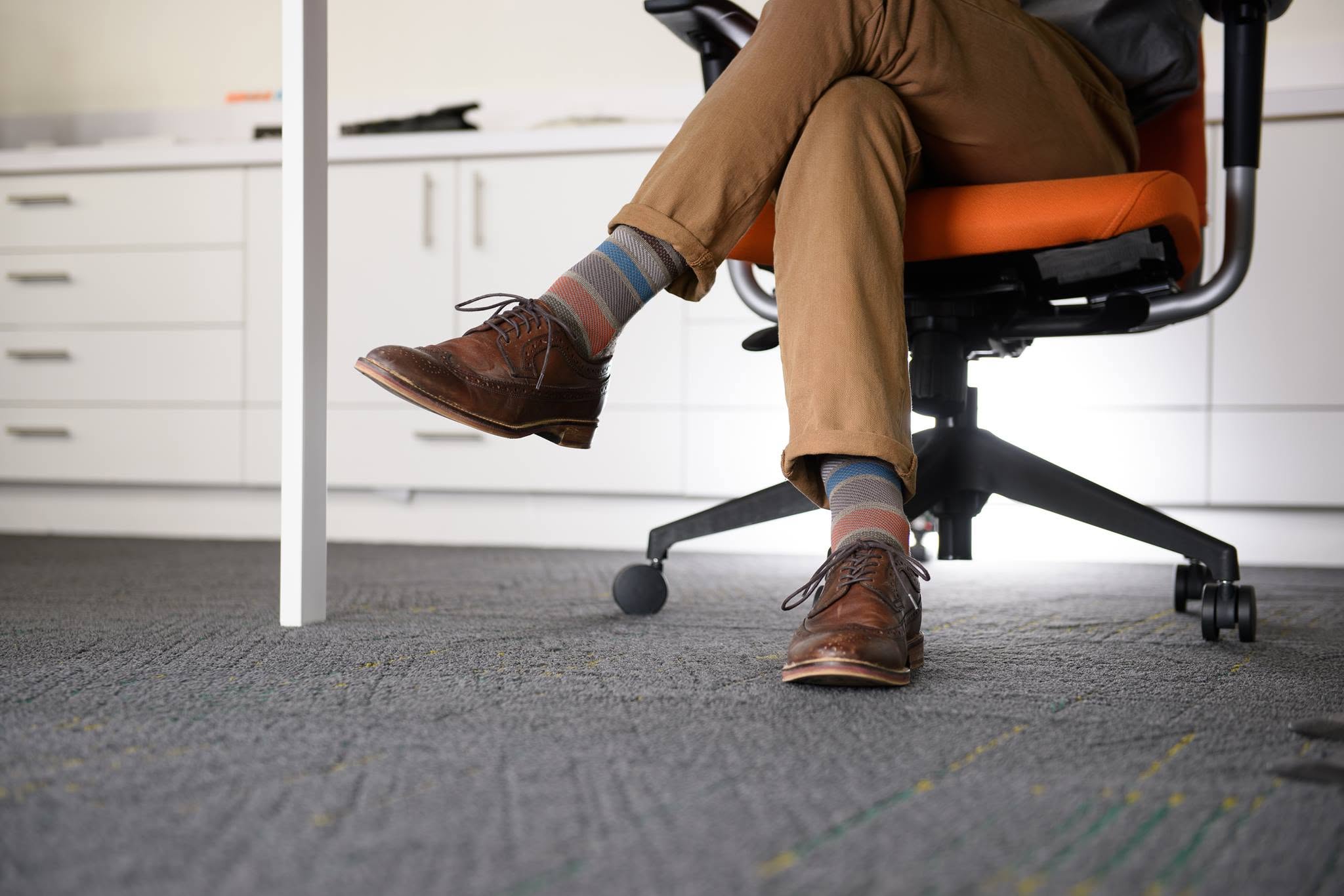 Man zittend met compressiekousen