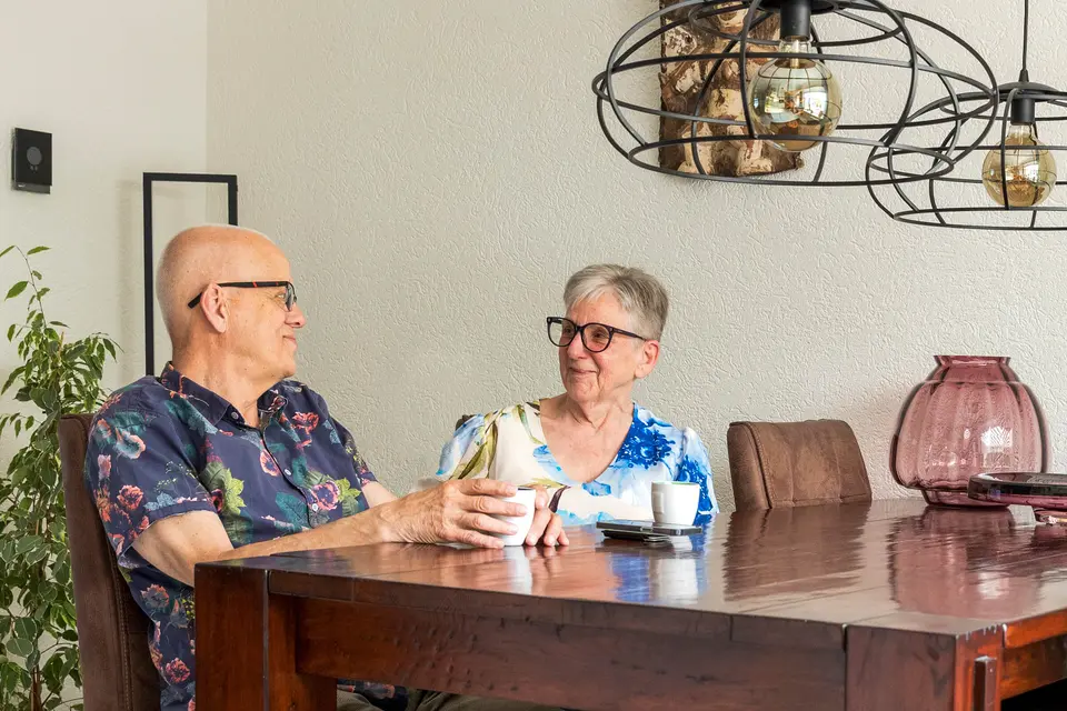Ouder stel aan de eettafel in hun woning