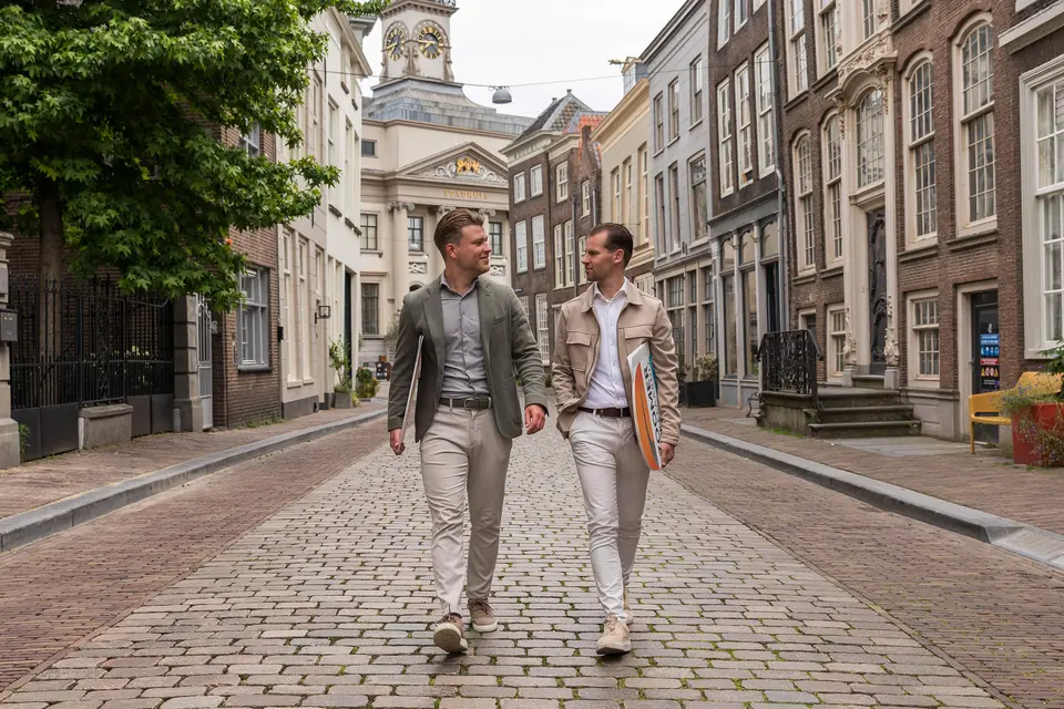 Aankoopmakelaars van Zoomer lopen door een straat in Dordrecht